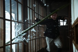 Ein Speer zerstört die Fenster - ein Polizist flüchtet (Quelle: Senator Home Entertainment)